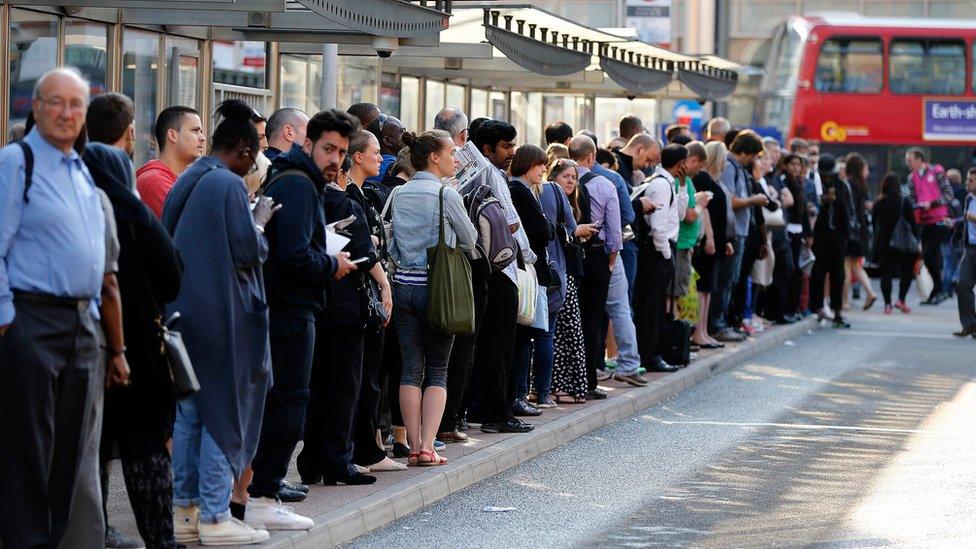 Commuters wait for a bus on Tube strike day