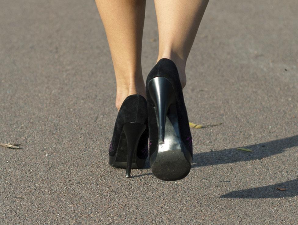 A close up of the feet of a woman walking in heels