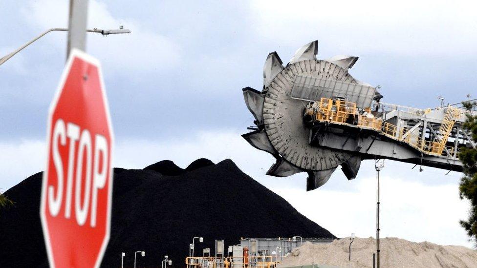 This picture taken on November 5, 2021 shows a bucket-wheel dumping soil and sand removed from another area of the mine in Newcastle, Australia - the world's largest coal exporting port.