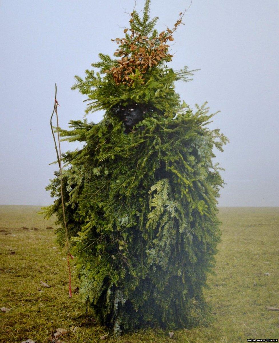 A person covered in leaves