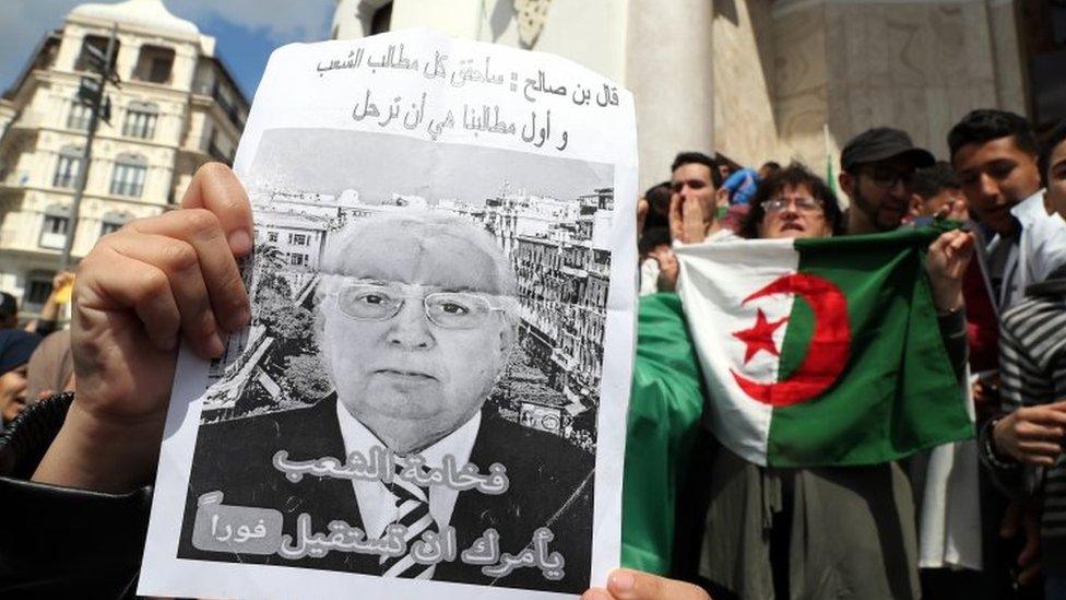 Protestor holds a black and white poster