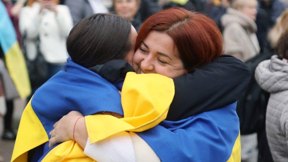 Residents of Kherson temporarily living in Odessa, wearing Ukrainian flags, celebrate the liberation of their native town