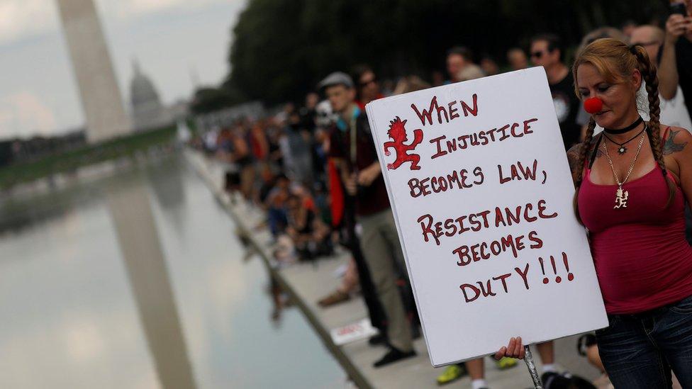 A woman holds up a sign saying "when injustice becomes law, resistance becomes duty" during a march in Washington