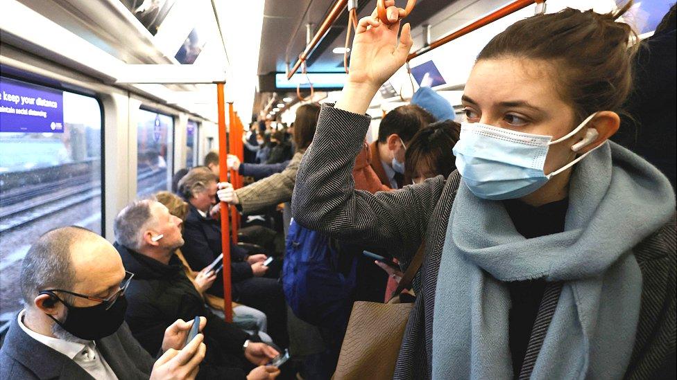 Commuters, some wearing face coverings, travel on a packed London Overground train service on 1 March 2022