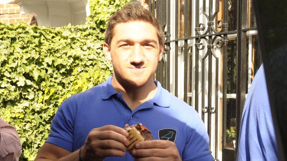 A Los Teros player eats a steak sandwich