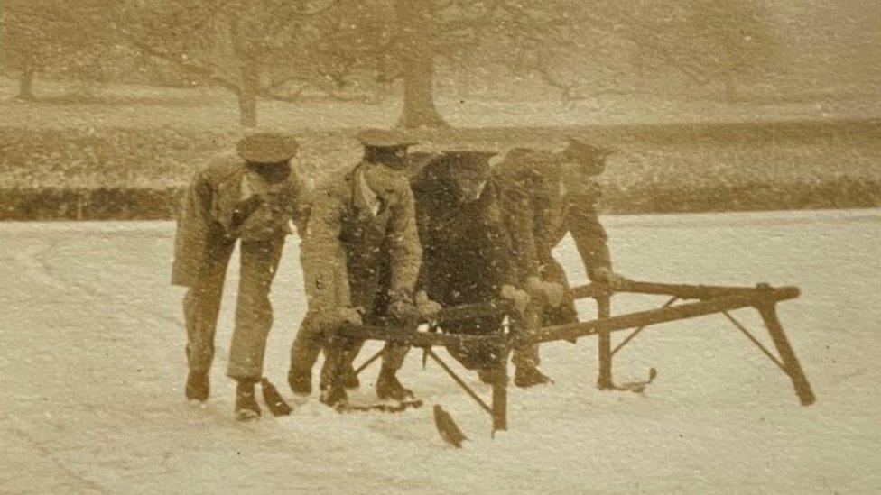 Four WW1 soldiers pushing makeshift tobogan in the snow at Longleat 1917