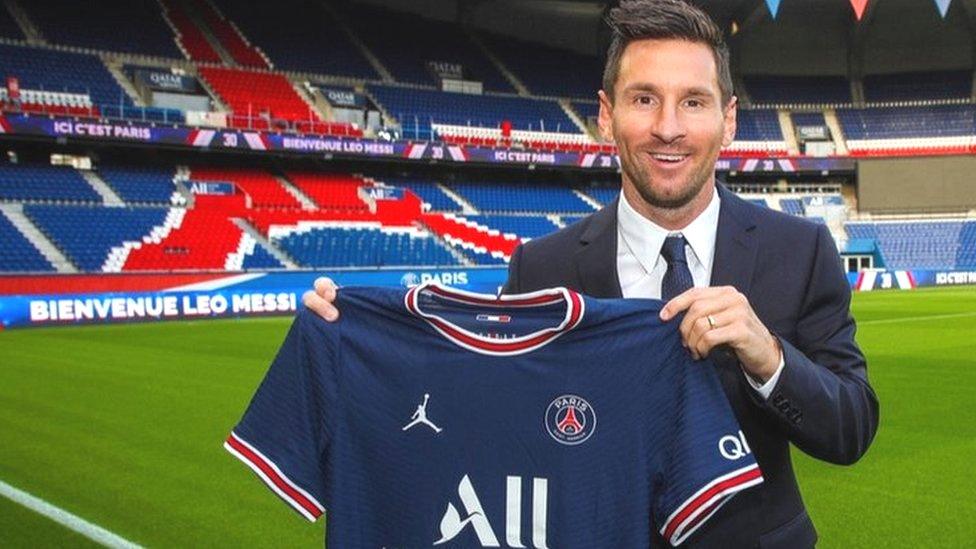 Lionel Messi posing with his PSG shirt