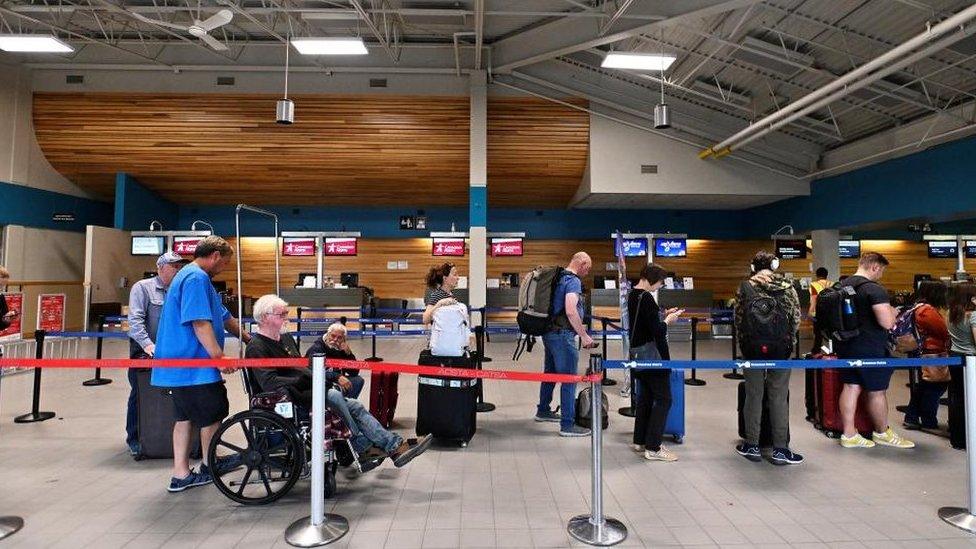 People wait in line at the airport, as they prepare to be evacuated from wildfires threatening the Northwest Territories town of Yellowknife, Canada, August 17, 2023. REUTERS/Jennifer Gauthier