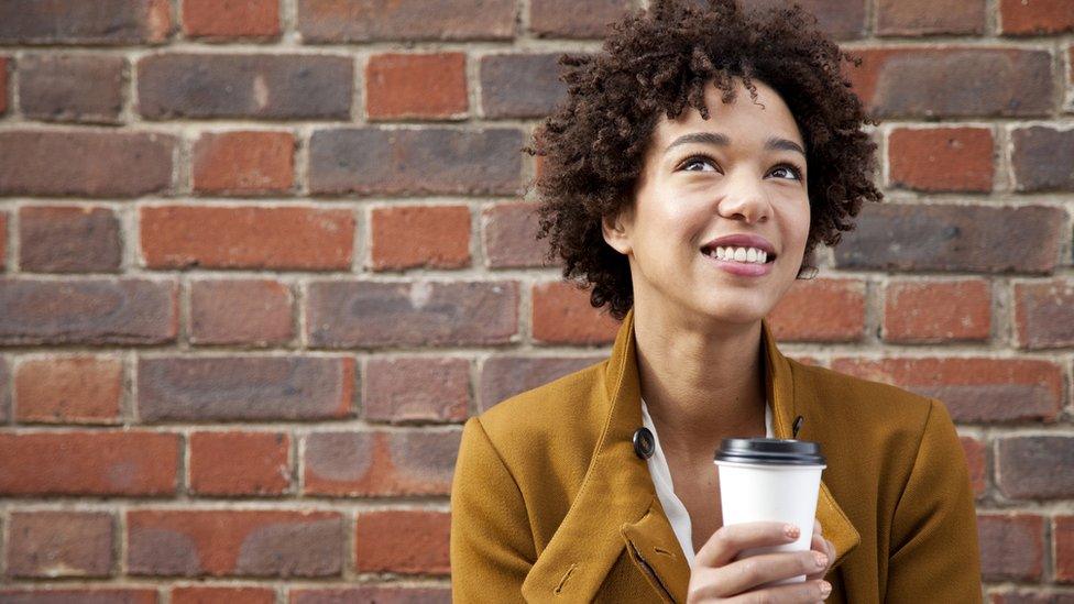 Woman holding takeaway coffee