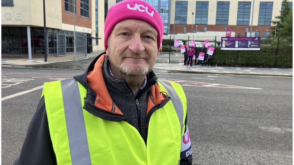 Dave Cresswell with picket line in the background