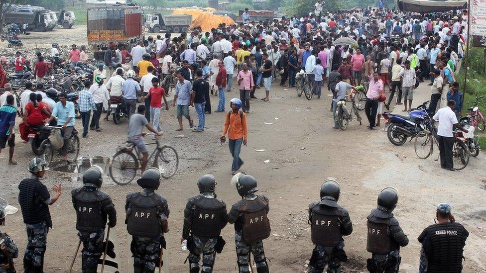 Nepalese policemen face protestors belonging to ethnic and religious groups dissatisfied with Nepal's new constitution adopted on Sunday