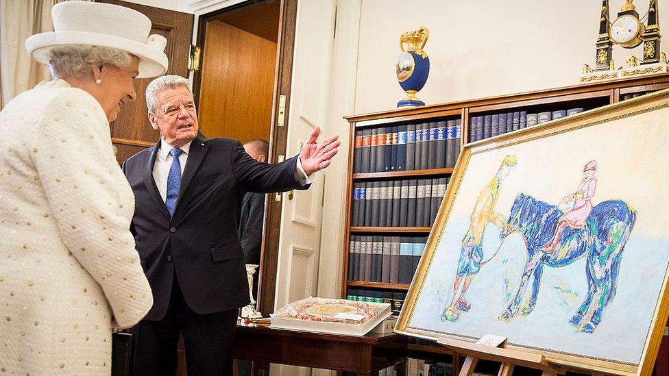 German President Joachim Gauck presents Queen Elizabeth II with a painting of her and her father entitled 'Horse in Royal Blue'