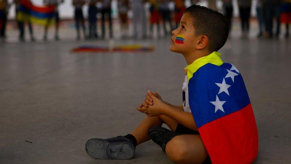 Five-year-old Benjamin sits as he accompanies his Venezuelan mother to a protest against the election results that awarded Venezuela's President Nicolas Maduro with a third term, in Ciudad Juarez, Mexico, August 3, 2024.