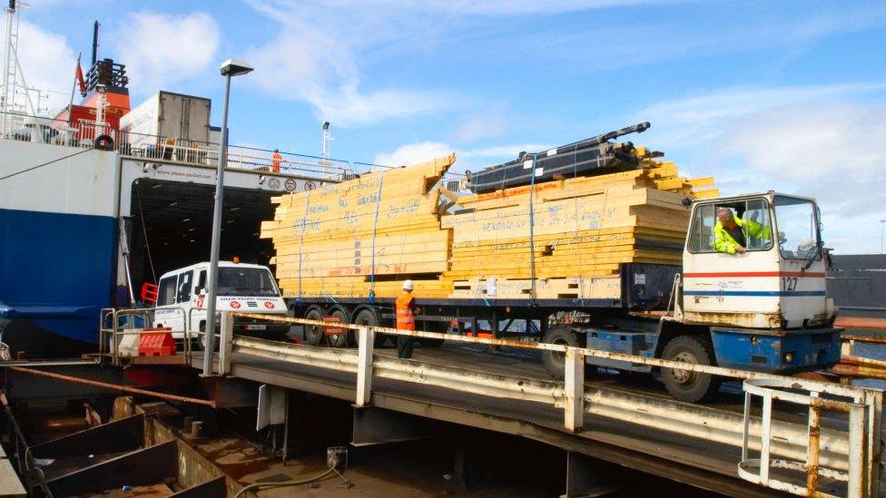 Timber on a lorry being loaded into a ship