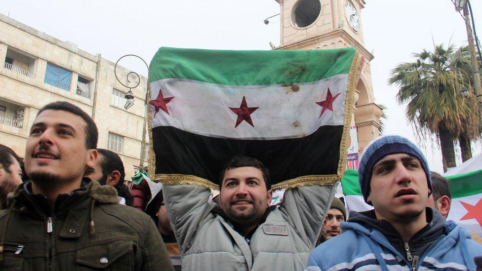 Syrian opposition supporters take part in a a protest calling for the overthrow of Syria's government in the city of Idlib (30 December 2016)