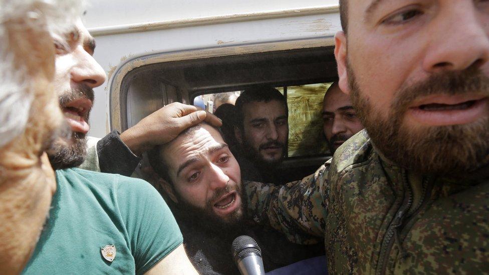 A vehicle transporting civilians and soldiers who the regime says were kidnapped by rebels and liberated in a prisoner swap arrives in a government-held area at the entrance of Harasta in Eastern Ghouta, on the outskirts of Damascus, on March 22, 2018