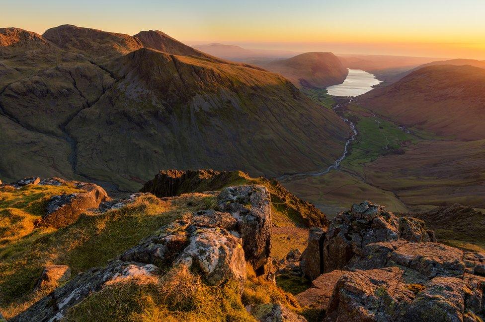 View looking down over Scafell Pike and Wastwater to the coast at sunset