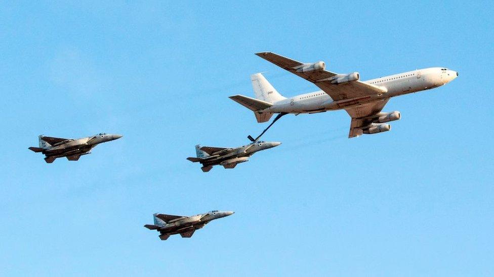 A Boeing KC-135 Stratotanker refuels an Israeli Air Force F-15 Eagle fighter jet flying in formation with two others, during an air show at Hatzerim base in the Negev desert (29 June 2017)