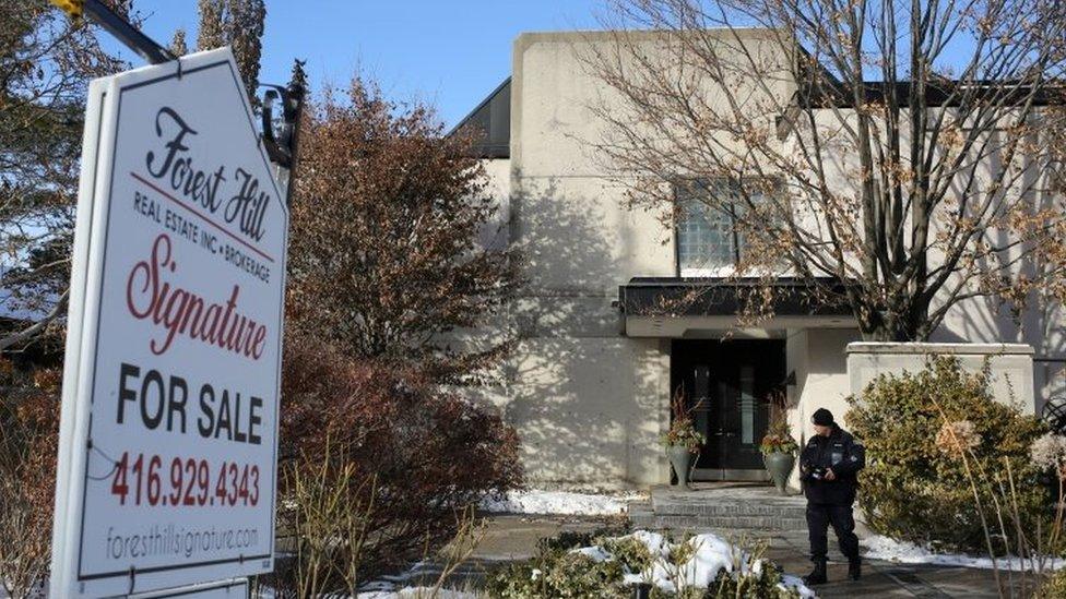 A police forensics photographer works outside the home of billionaire founder of Canadian pharmaceutical firm Apotex Inc., Barry Sherman and his wife Honey, who were found dead a day earlier in Toronto, Ontario, Canada on 16 December 2017.