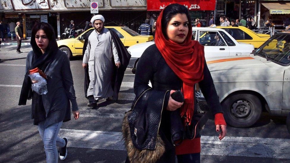 Pedestrians cross a square a day after parliamentary and Experts Assembly elections in Iran, Saturday, Feb. 27, 2016