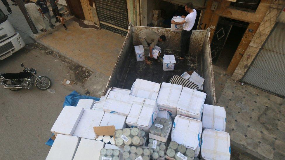 Workers unload food aid in Aleppo