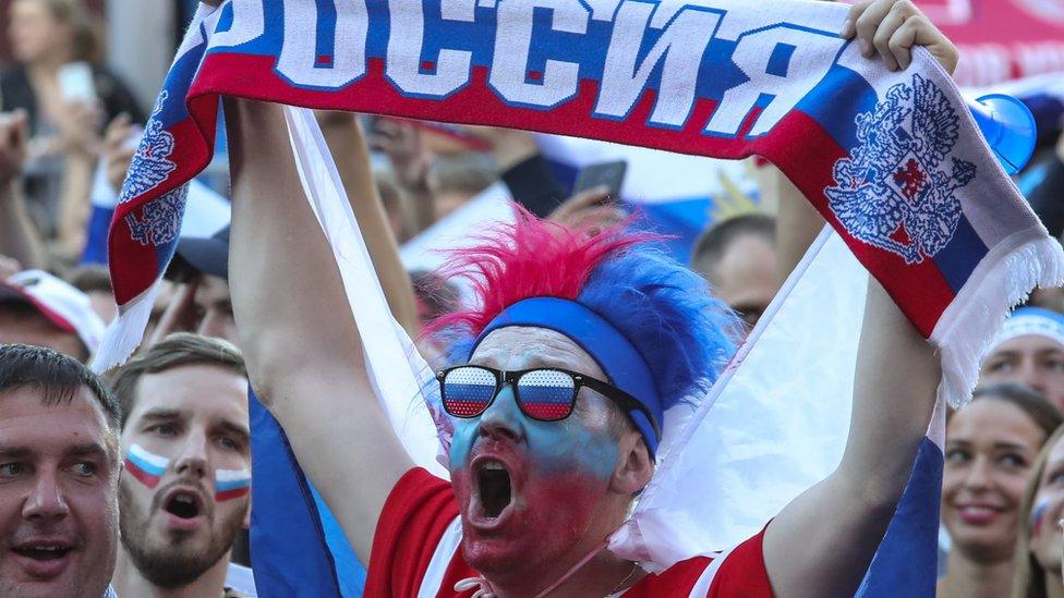 A fan raises a Russia scarf at the FIFA World Cup 2018 quarter final in St Petersburg, 7 July 2018