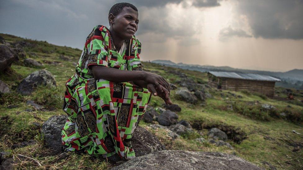 Anette Ntakirutimana sits on a rock