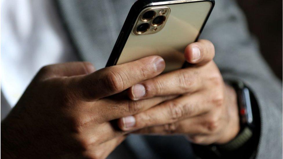 A man uses an iPhone 13 Pro Max at a restaurant in Baramulla Jammu and Kashmir India on 19 March 2022