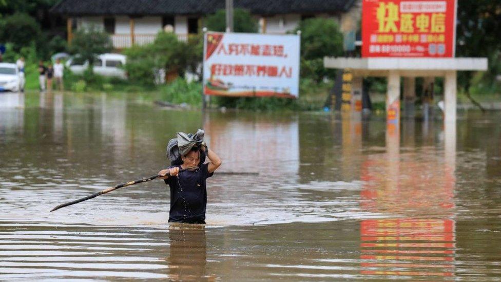 A man wades through floodwater in Rongan in China's southern Guangxi region