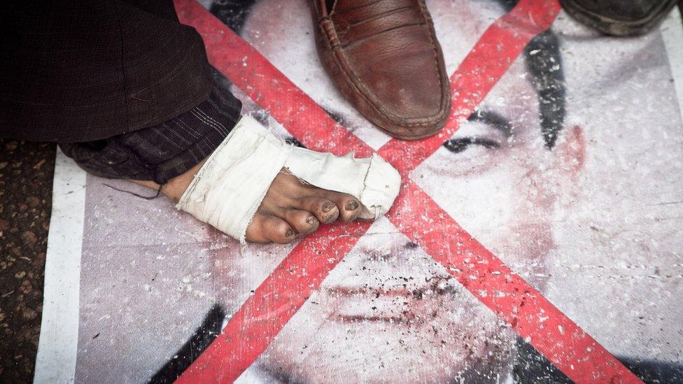 Protester stepping on poster of Mubarak