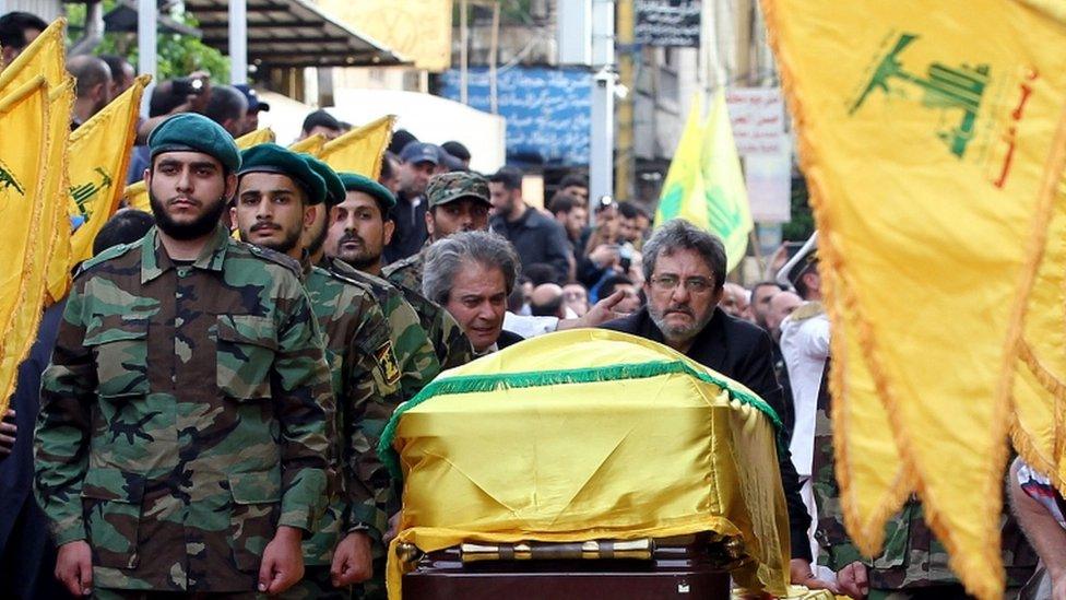 Adnan (C-L) and Hassan Badreddine (C-R), brothers of slain top Hezbollah commander Mustafa Badreddine who was killed in an attack in Syria, mourn next to his casket during the funeral in the Ghobeiry neighbourhood of southern Beirut on 13 May 2016