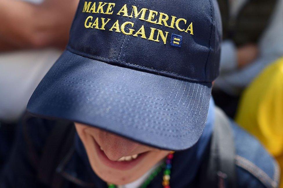 A man wearing a Trump-inspired hat watches the San Francisco pride parade