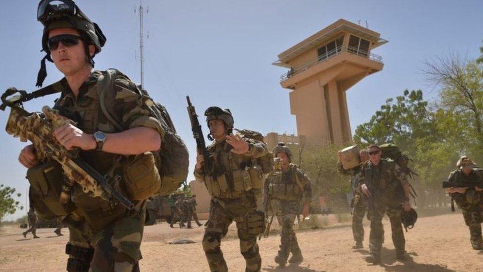 French legionnaires who were parachuted into Timbuktu in January 2013 to retake the northern Mali city, walk to Timbuktu airport days later to board a plane that will take them back to their base in Abidjan.