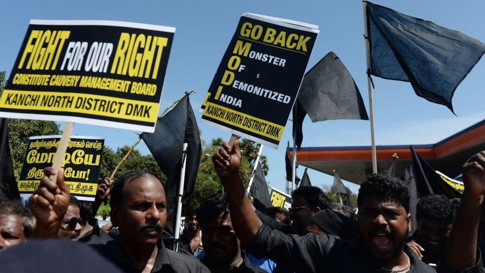 Indian police detain demonstrators holding black flags and placard during a protest against Indian Prime Minister Narendra Modi near airport during his visit to Chennai on April 12, 2018