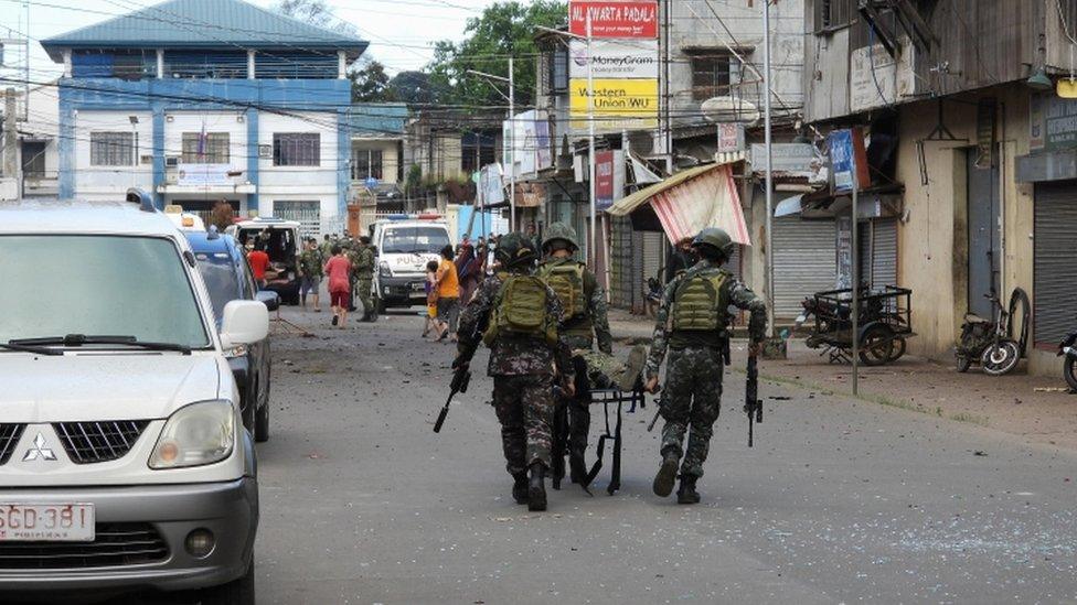 Filipino soldiers carry a comrade on a stretcher, after an explosion in Jolo Island, Sulu province, Philippines