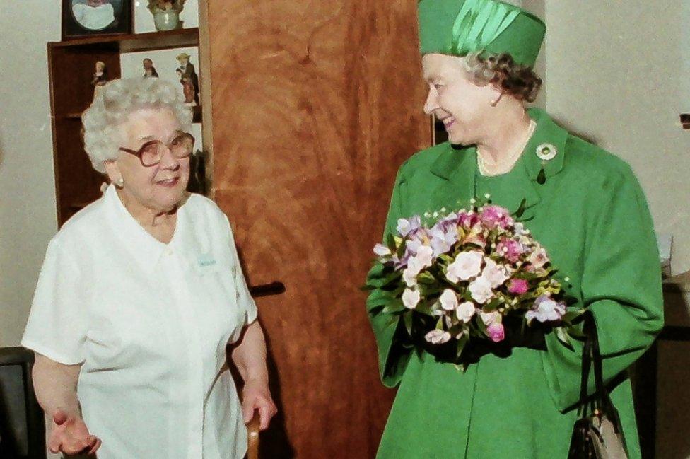 The Queen meets a woman in a flat