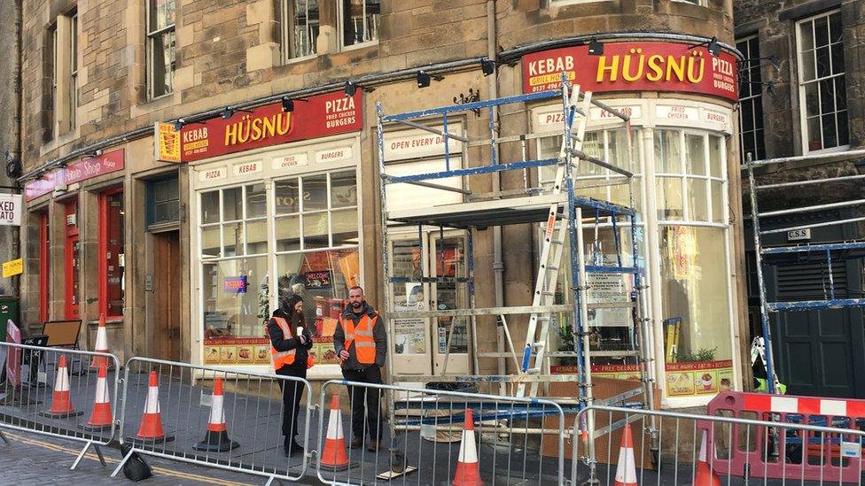 A kebab shop set has signs reading "We will deep fry your kebab"