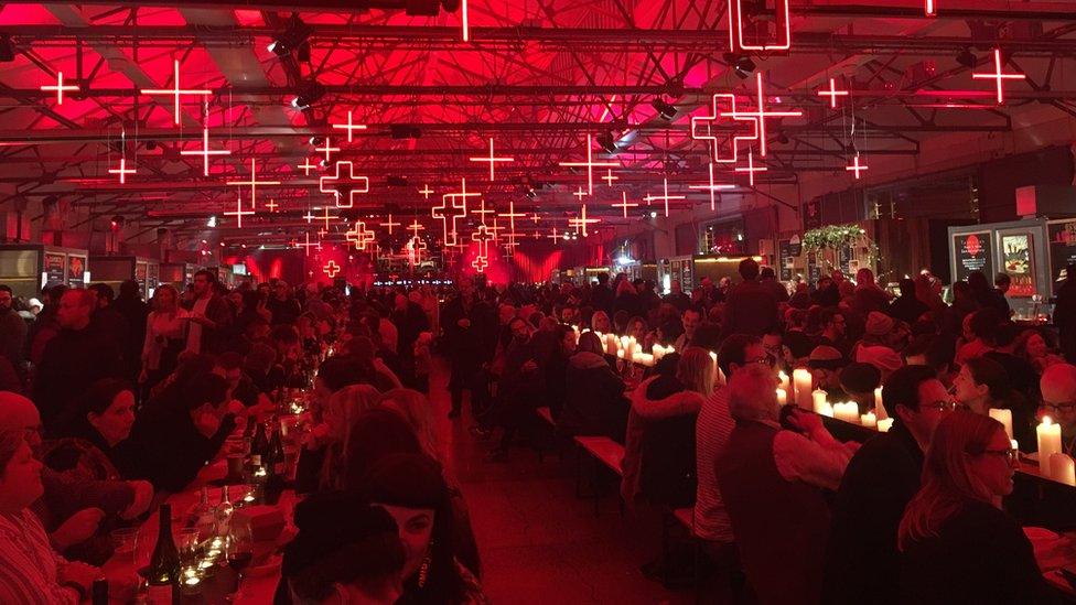 People sit in rows for a public feast at the festival