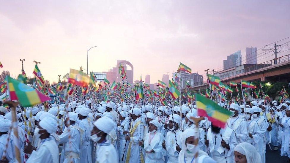 Crowd dressed in white with Ethiopian flags