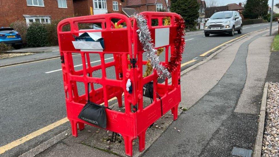 Roadwork barrier draped in tinsel