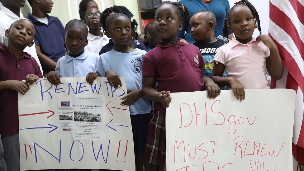 Children hold posters asking the Federal government to renew Temporary Protected Status