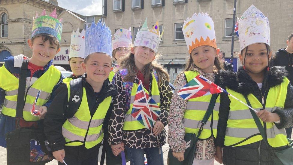 Children wearing homemade crowns and waving flags