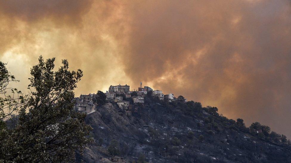 Smoke rises from a wildfire in the forested hills of the Kabylie region, east of the capital Algiers, on August 10, 2021.