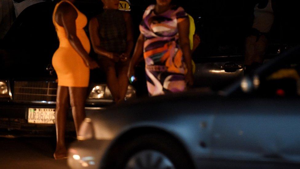 Three sex workers stand on the street in Benin City, capital of Edo State, southern Nigeria