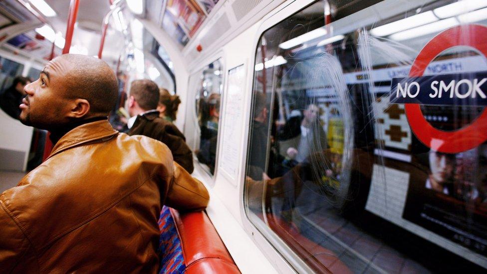 A passenger looks up at the Underground map