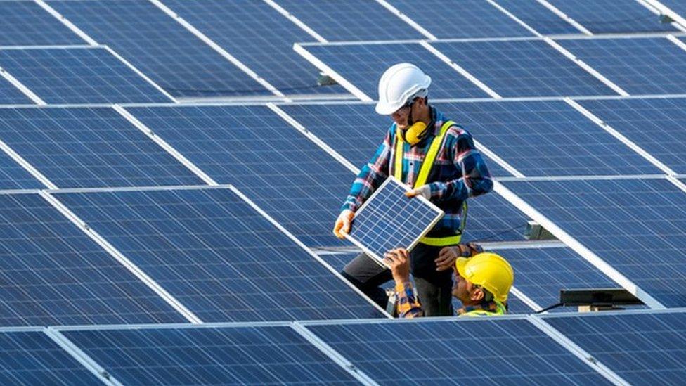 Technicians fitting solar panels