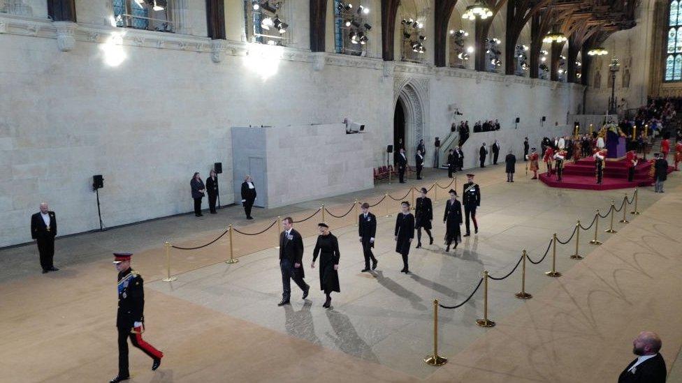 The Queen's grandchildren walking towards her coffin