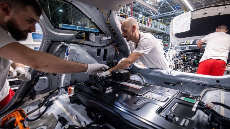 Workers install an electric battery inside a Kia Ceed Sportswagon plug-in hybrid electric vehicle on the assembly line at the Kia Slovakia sro plant in Zilina, Slovakia, on Friday, Oct. 27, 2023