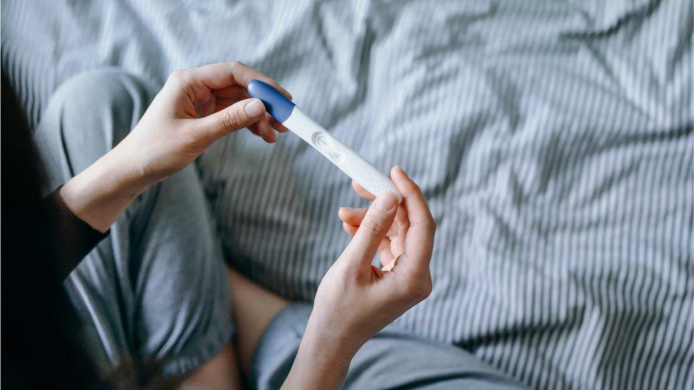 Woman holding pregnancy test