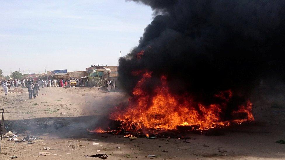 A fire is lit along the street during protests against price increases in Atbara, Nile River state, Sudan, 20 December 2018